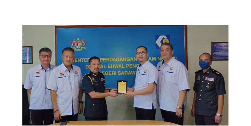 马来西亚国家消费者基金会砂分会主席林杭辉（右三）在众人陪同下，赠送纪念品给砂贸消局代总监彼得本立努斯。 右二为秘书林以群；左起为副主席张智超和财政蔡美新。