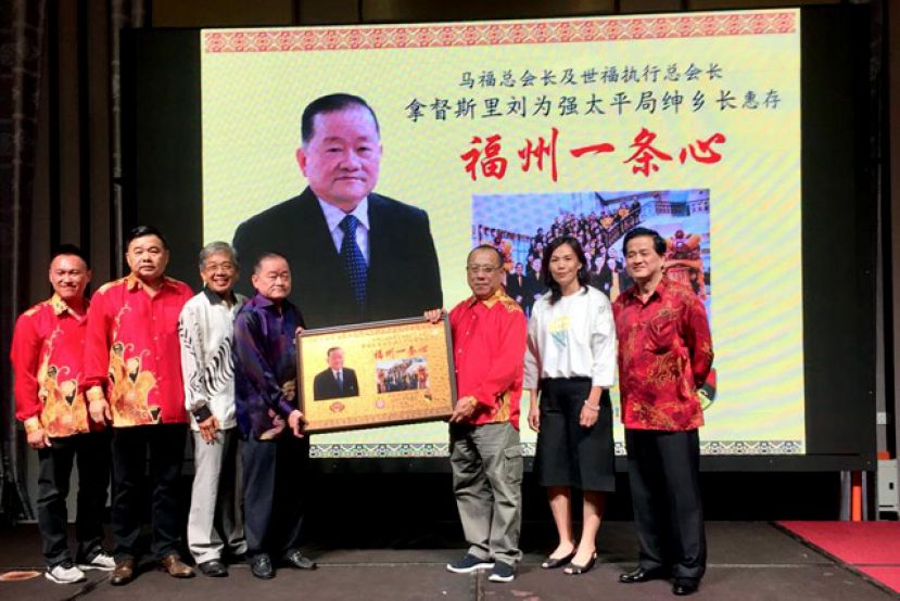 森美兰福州会馆会长徐孝轼（右三）赠送纪念品予马福总会长拿督斯里刘为强太平局绅（左四）时摄。右起为马福总财政俞贵狮博士及拿汀斯里苏秀燕。左起则是森美兰福州会馆青年团团长张荣通、森美兰福州会馆署理会长拿督叶理国及马福署理会长拿督董仕星。