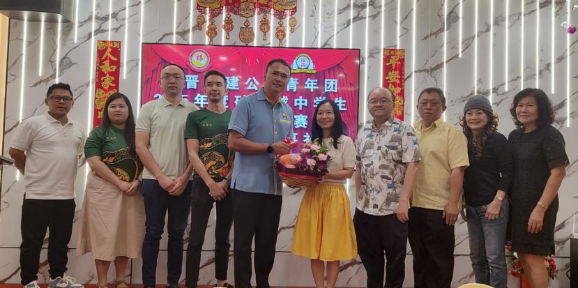 在众嘉宾的陪同下，筹委会主席甲必丹陈俊贤（左五）赠送纪念品予砂总理署政治秘书许德婉时影。