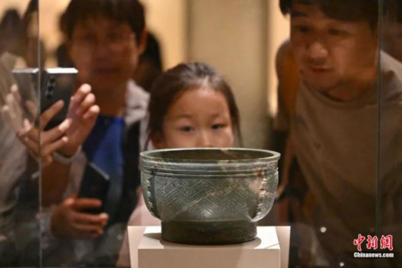 家长与小朋友在北京的中国国家博物馆观看展出的玉簋(商代)。