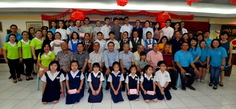 获得奖励金的会员子女和古晋海南公会理事合影。