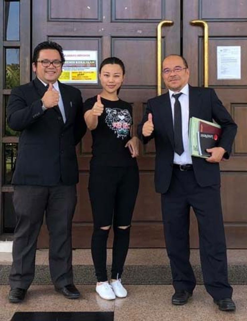 女被告（中）在获得无罪释放后和辩护律师史迪芬杯迪（右）以及杰罗多纳在法庭外合影时竖起拇指。