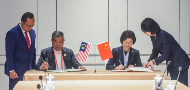 末沙布(左)与中国海关总署署长孙梅君签署议定书。