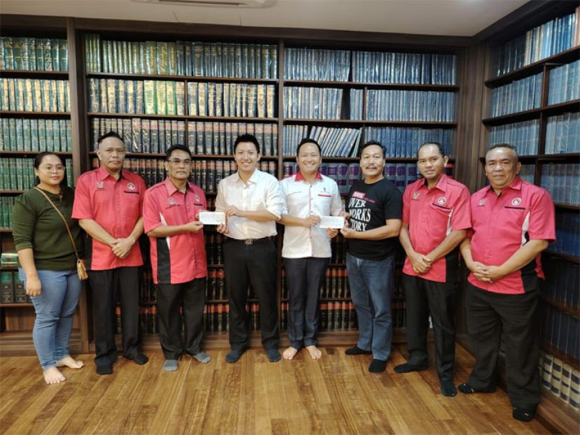 张健仁特别助理江峰年（右四）将拨款移交予古晋退伍军人福利协会会长丹尼斯（右三）。张健仁特别助理沈杰龙（左四）将拨款移交予砂拉越退伍军人协会会长法兰西斯（左三）。