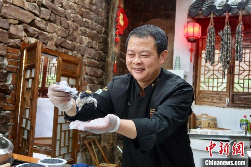浙江金华黄大仙饮食文化传承基地负责人、金华乌饭制作技艺传承人李桂华展示乌饭。