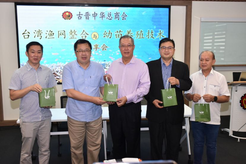 台湾国立高雄科技大学的刘仁铭（左二）赠送纪念品予古晋中华总商会副会长郭应茂（右三），右一起为农业组副主任本固鲁李开喜、农业组主任卢少奎，右一为农业组副主任张毓伦。