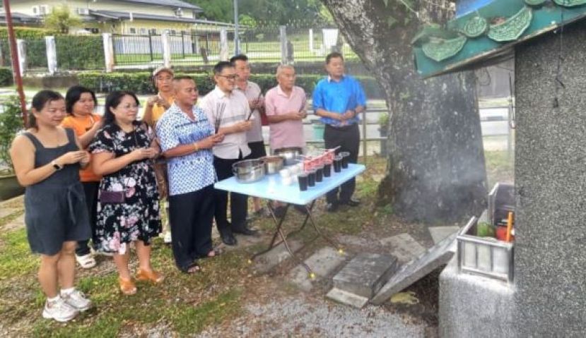 薛华东（前排中）与甲必丹林传政（左3）及信众在亚答街大树底下的拿督公神龛进行开斋节膜拜。