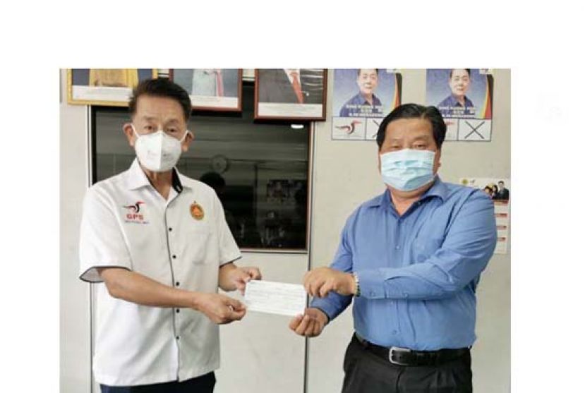 马拉端区州议员陈冠勋（左）移交小型发展金拨款予砂医总会长江宗兴供推动会务。