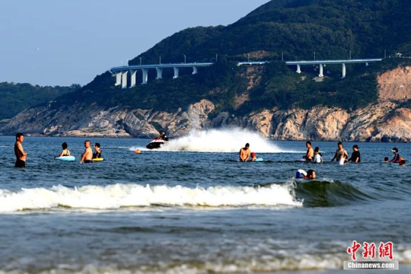 民众到金銮湾景区海边玩水休闲。