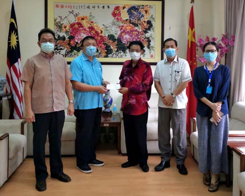 中国驻古晋总领事程广中（右三）移交5万令吉捐款予晋汉连省津贴华小董联会会长蔡文铎（左二），右一为蒋盈领事。