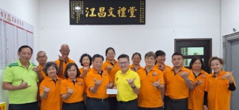 中砂六桂堂宗亲会主席江宗兴（左4）由钱进一手中接收拨款支票；左2起为妇女组组长龚巧芳、甲必丹江丽訇、右四为副主席洪荣裕等人。