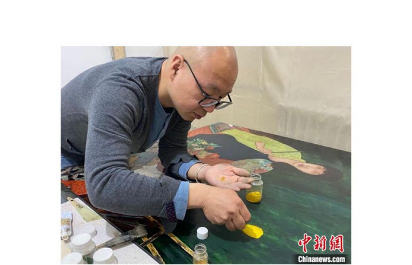 姚小乾在制作漆画。