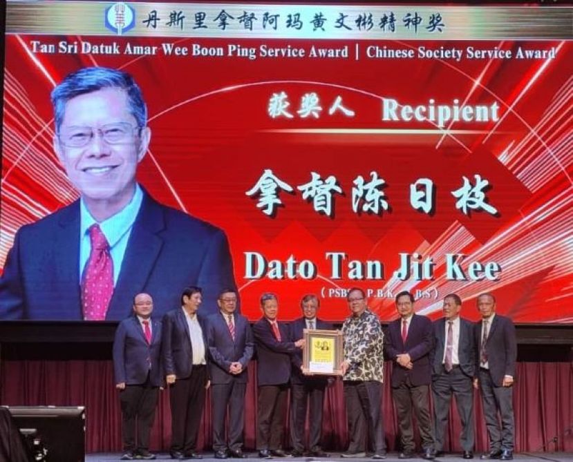 在砂总理阿邦佐哈里（中）见证下，黄文彬集团董事拿督黄国辉（右四）颁发丹斯里拿督阿玛黄文彬精神奖的华社服务奖予拿督陈日枝（左四）时影。