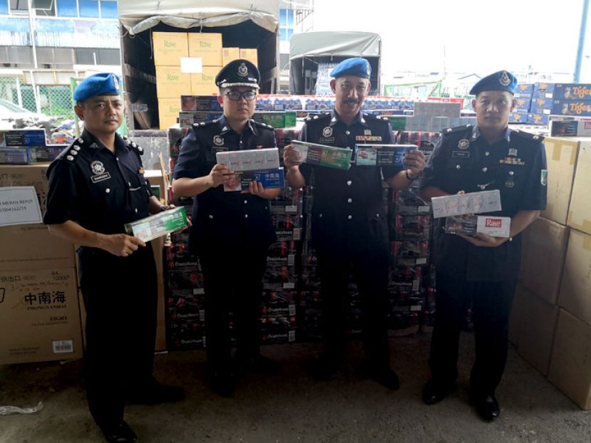 砂水警破获全砂最大宗走私烟酒案。代指挥官阿都拉曼玛哈山警监（右二）与莫哈末沙朗助理警监、江贤政警长（左一及二）及法哈副警监（右一）展示起回的私烟私酒。