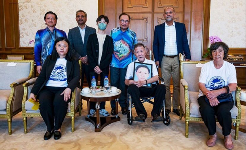 首相安华会晤赵明福家属。前排坐轮椅者为爸爸赵亮辉，妈妈张秀花(右一)和赵丽兰(左一)。后排右起为卡巴星、首相安华、赵尔家、蓝卡巴和黄业华。
