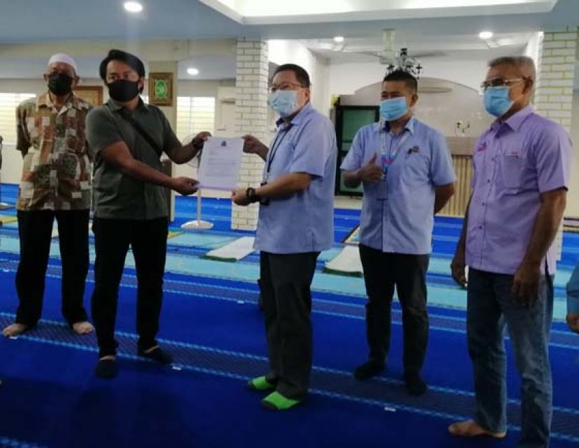 古晋南市市长拿督黄鸿圣（右三）移交提升回教堂设备的文件予承包商。