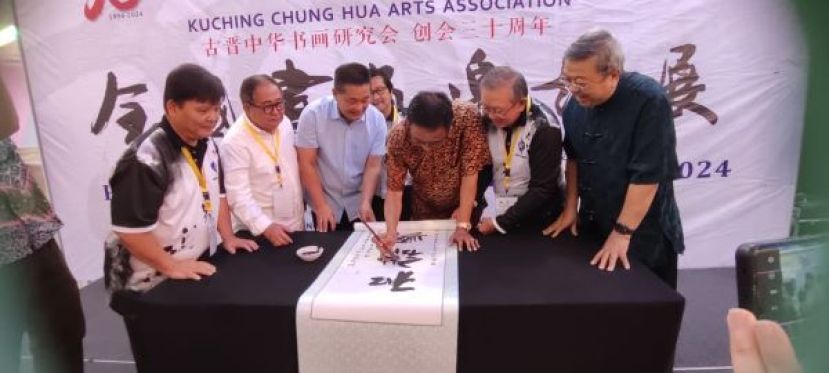 砂拉越旅游、创意产业及表演艺术部长拿督斯里阿都卡林握起毛笔，为古晋中华书画研究会所举办的&ldquo;已故创会会长郭才标老师遗作展暨书画活动主持开幕礼。