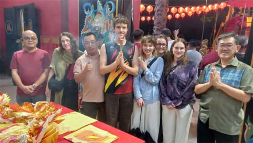 主宾薛华东（右）在毕打拿忠福宫拜天公仪式现场陪入庙随俗德国男女游客烧香膜拜神明。左为黄昭信市议员。