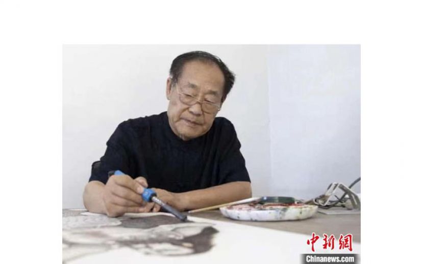 贾书辰在进行烙画创作。