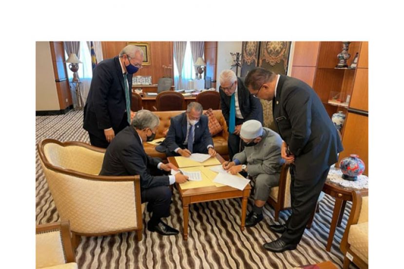 土团党主席丹斯里慕尤丁（中），伊党主席拿督斯里哈迪阿旺（右二）和国阵主席拿督斯里阿末扎希（左）共同签署文件。
