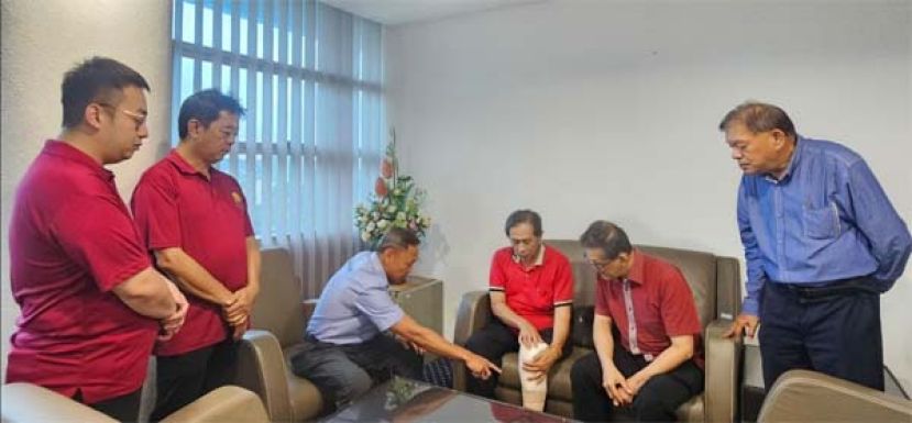 社险砂局长陈邦正（左3）观察陈惠生所装的社险提供义肢。左起为许义华、田升宏；右起是陈中兴、薛华东。
