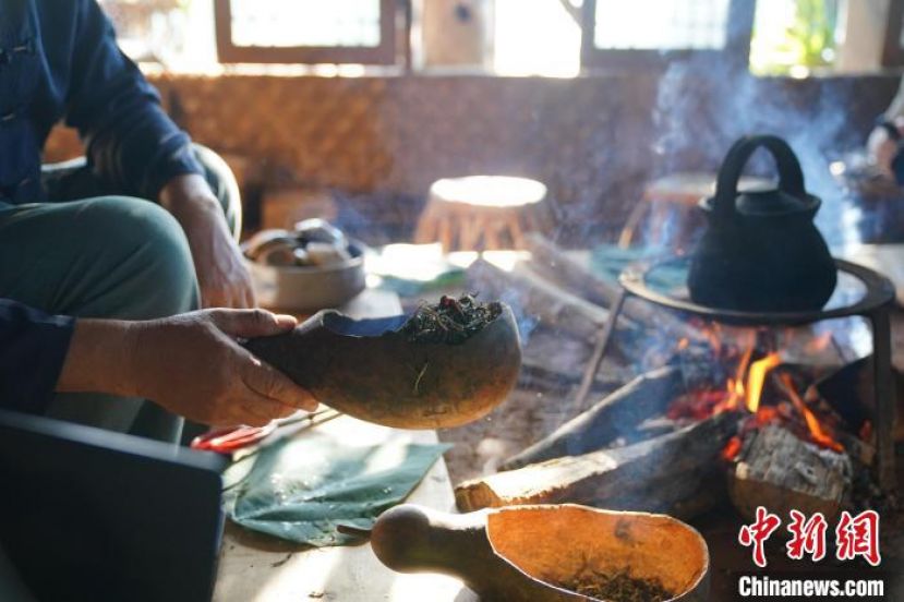 云南普洱景迈山布朗族人在火塘边制作烤茶。