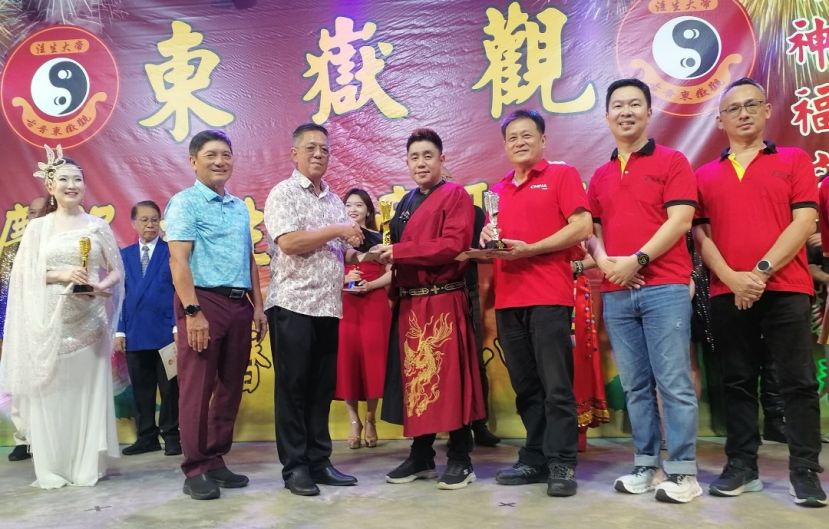 主宾天猛公拿督陈如飞（前排左3）颁发华语歌唱混合赛冠军奖予艾伦。左2是庆典大会会长方明生；右起为副炉主田亚胜、筹委主席吴志鸿、古晋东嶽观主席兼大会会长方文祥太平局绅。
