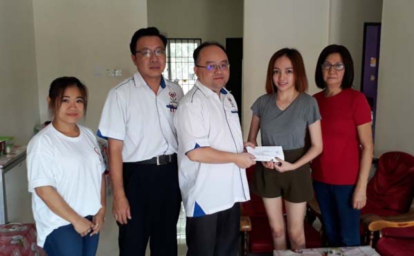 甲必丹拿督劉思樂（中）在馬來西亞善心組織古晉理事田志和（左二）的見証下，代表該組織移交馬幣一萬令吉捐款予彭佳欣。(右)為其母親李桂珠、(左一)為該組織古晉義工楊琍鈉。