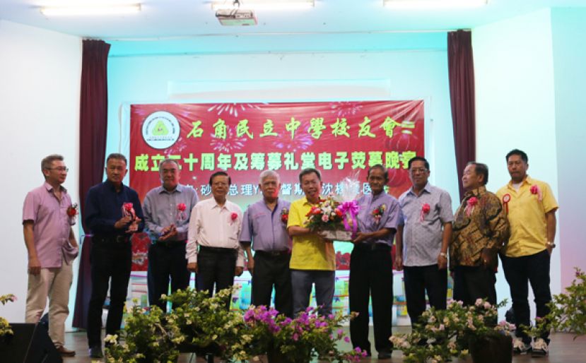 右起第四为石角民立中学校友会主席蔡高仁，赠送纪念品给砂拉越副总理拿督斯里沈桂贤医生。右起为甲必丹陈君義、民中董事长朱聪泽、天猛公陈如飞、晚宴筹委会主席张孙发、拿督叶金来律师、拿督蔡文铎律师代表何晋兴、天猛公刘石星代表蔡美新、晚宴总赞助人杨敬森校友。