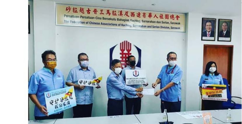 在晋汉连省华总会长拿督黄良杰（左四）的见证下，古晋中华总商会会长拿督陈日枝（左三）移交支票予华总支援砂拉越抗疫基金筹委会主席郭应茂（右二）左起为该筹委会副主席田松茂、中华总商会署理会长拿督黄国辉以及右一为晋汉连省华总妇女组主席张慧娇。