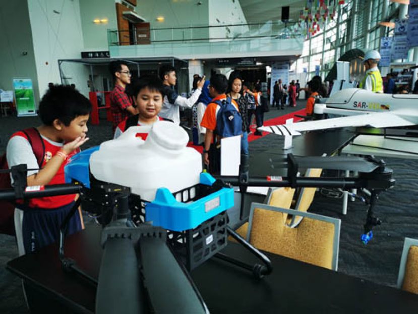 小学生参观无人机时露出惊叹的表情。