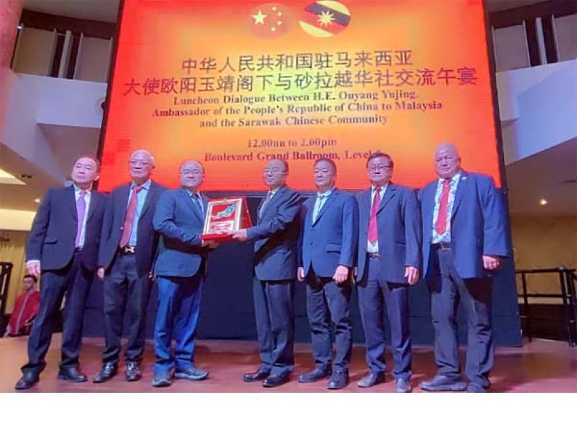 砂拉越福州社团联合总会总会长甲必丹拿督刘思乐（左三）赠送纪念品予中华人民共和国驻马来西亚大使欧阳玉靖（右四）时影。左起为砂拉越福州社团联合总会副会长林唐锦和砂拉越福州社团联合总会副会长刘锦虎。右起为砂拉越福州社团联合总会副会长拿督许道雄、砂拉越福州社团联合总会署理主席刘恭福以及砂拉越福州社团联合总会副会长李悦兴。