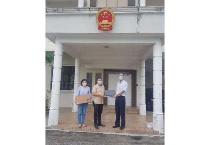 张阳副总领事（右）把教学设备移交予天猛公郭翼升（中）时摄。