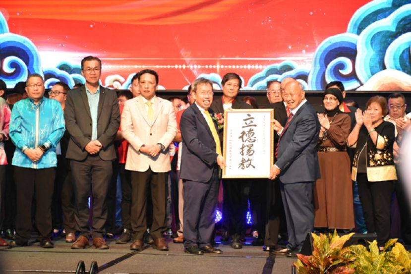 砂德教会紫霞阁阁长拿督斯里郑正金（右三）赠送纪念品予砂总理代表砂副总理拿督斯里沈桂贤（左四）。