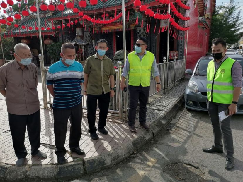 甲必丹林传政（左二）向北市行政委员薛华东（中）反映亚答街一带街道应重铺沥青。