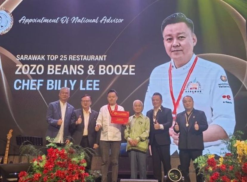 砂拉越美食文化交流协会颁发敦聘书予砂拉越25大餐厅之一Zozo Beans &amp; Booze主厨李佳纹（左三），委任其为该会顾问，期望借助其专业与经验，推动协会进一步发展，为同业争取更多福利。颁发敦聘书后，众人合影留念。右起为筹委会主席拿督陈芍稳、大会主席旺州以及古晋著名的资深餐饮企业家符气元；左起为该会第三副主席莫龙强。