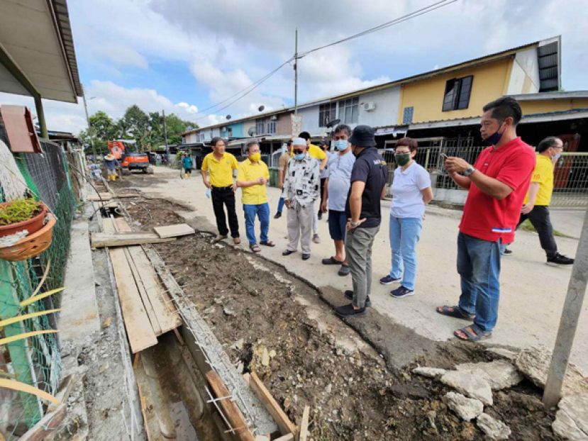 拿督斯里沈桂贤（左二）巡视大马道路档案系统下推行的石角路廉价房屋沟渠提升工程。