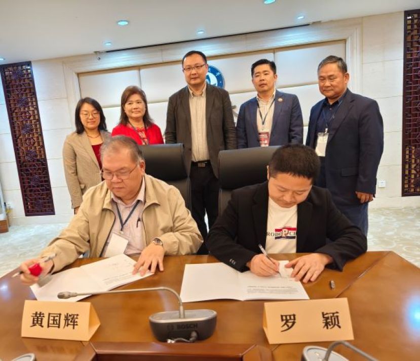 马来西亚砂拉越&ndash;中国友好协会常务副会长拿督黄国辉（左）与暨南大学招生办公室副主任罗颖（右）代表双方签署合作协议，见证双方教育与文化交流合作新里程。