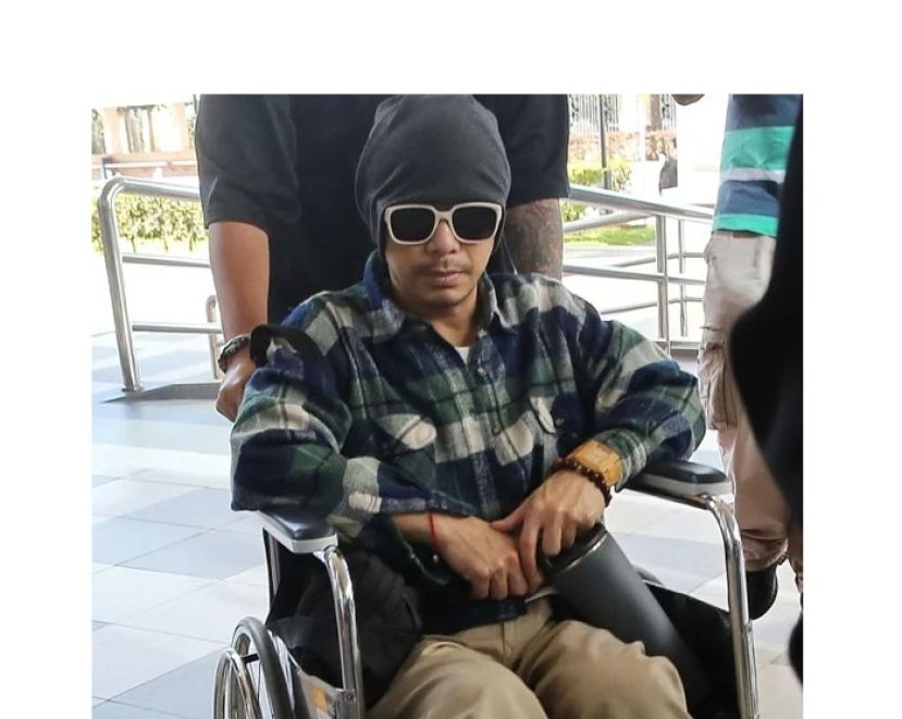 黄明志坐轮椅上法庭。