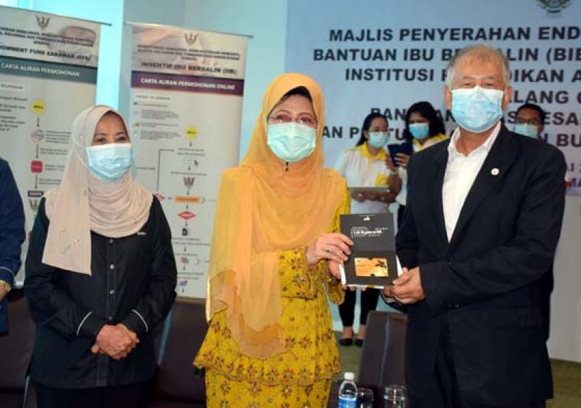 拿督陈超耀助理部长从拿督斯里陈赛明手中接过卑骚区的肯雅兰金卡。左是罗茜助理部长。