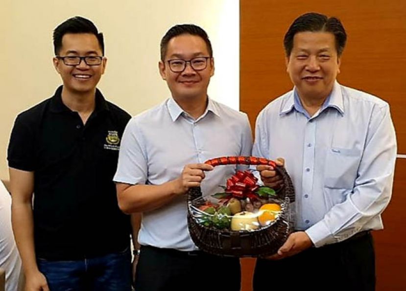 砂医总会长江宗兴（右）赠送水果礼蓝予砂首长署政治秘书程明智；左为副会长江邦仲。