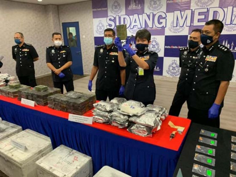 吉隆坡副总警长拿督杨丽珠（右三）展示警方侦破毒品案的毒品。