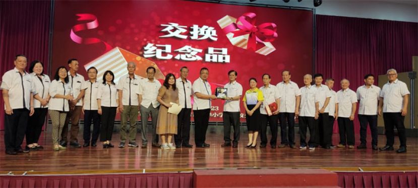 两所小学校董会主席交换礼物。