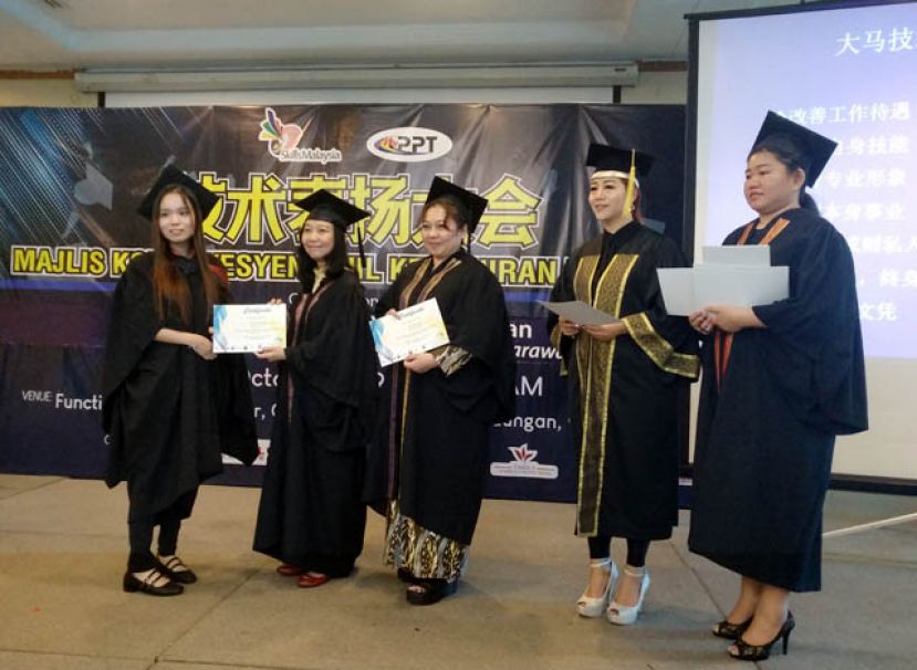 古晋南市市议员许德婉（左二）在大马技术文凭考官吴绍霞（右二）及女孩化妆美容学院院长杨芳妮（右）的陪同下，颁发证书予其中一名毕业生（左）。