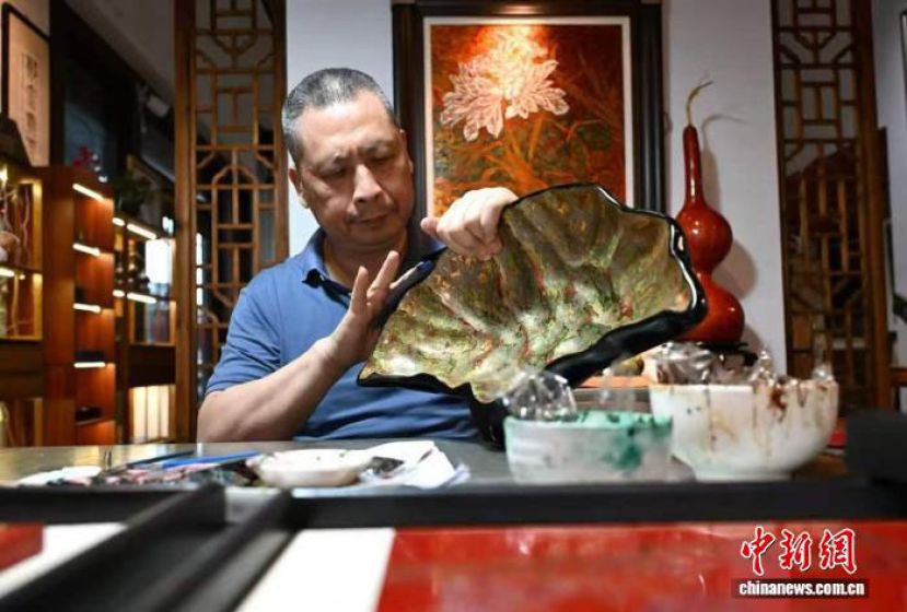 在中国传统工艺美术大师郑云涛的福州工作室内，他正在打磨一件形如果盘的文创产品。