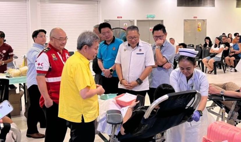 沈桂贤在众人的陪同下，与捐血者交流。