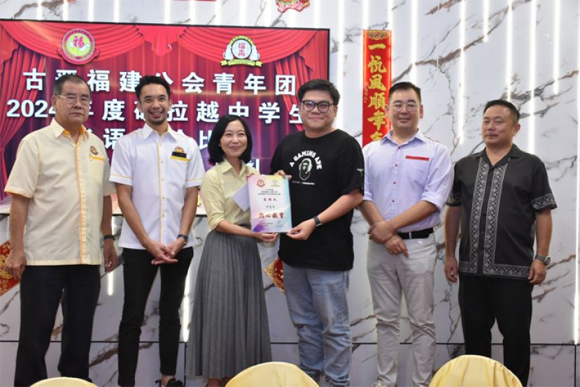 砂总理署政治秘书许德婉（左三）颁发感谢状予辩论赛的裁判。左一起为大马福联会副会长暨古晋福建公会监察主席郑文新、古晋福建公会青年团团长暨大马福联青理事黄惟玄，右一为古晋福建公会秘书长甲必丹陈国璋与辩论比赛筹委会主席黄冀义。