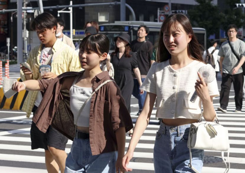 日本名古屋高温炎热，街头民众手持小电风扇。