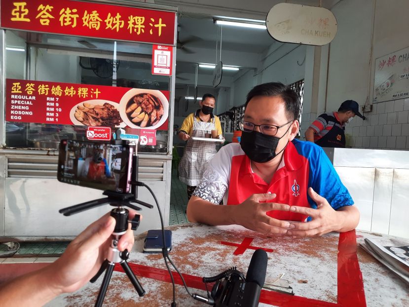 行动党浮罗岸区候选人张健仁今早在咖啡店进行面子书直播。