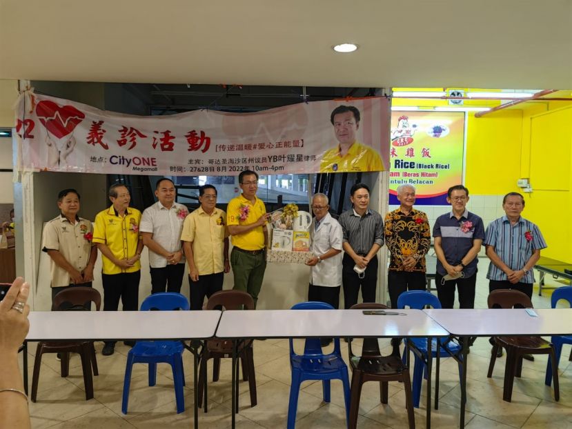 古晋传统中医与整合自然医学公会会长田明东（右五）赠送纪念品予爱心义诊活动主宾哥达圣淘沙州议员叶耀星（左五）。